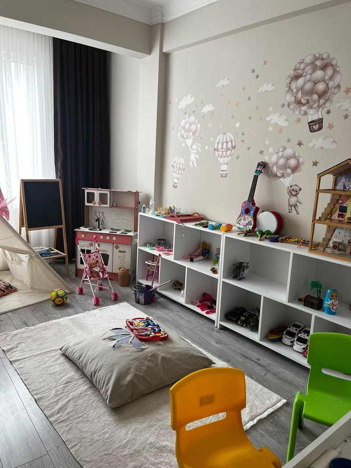 Oyun odasında minderler, küçük sandalyeler ve oyuncaklar