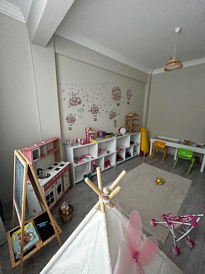 Çocuk odasında küçük çalışma masası, sandalyeler ve oyun çadırı